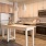 Spacious and well lit kitchen with wood floors and stainless steel appliances. 